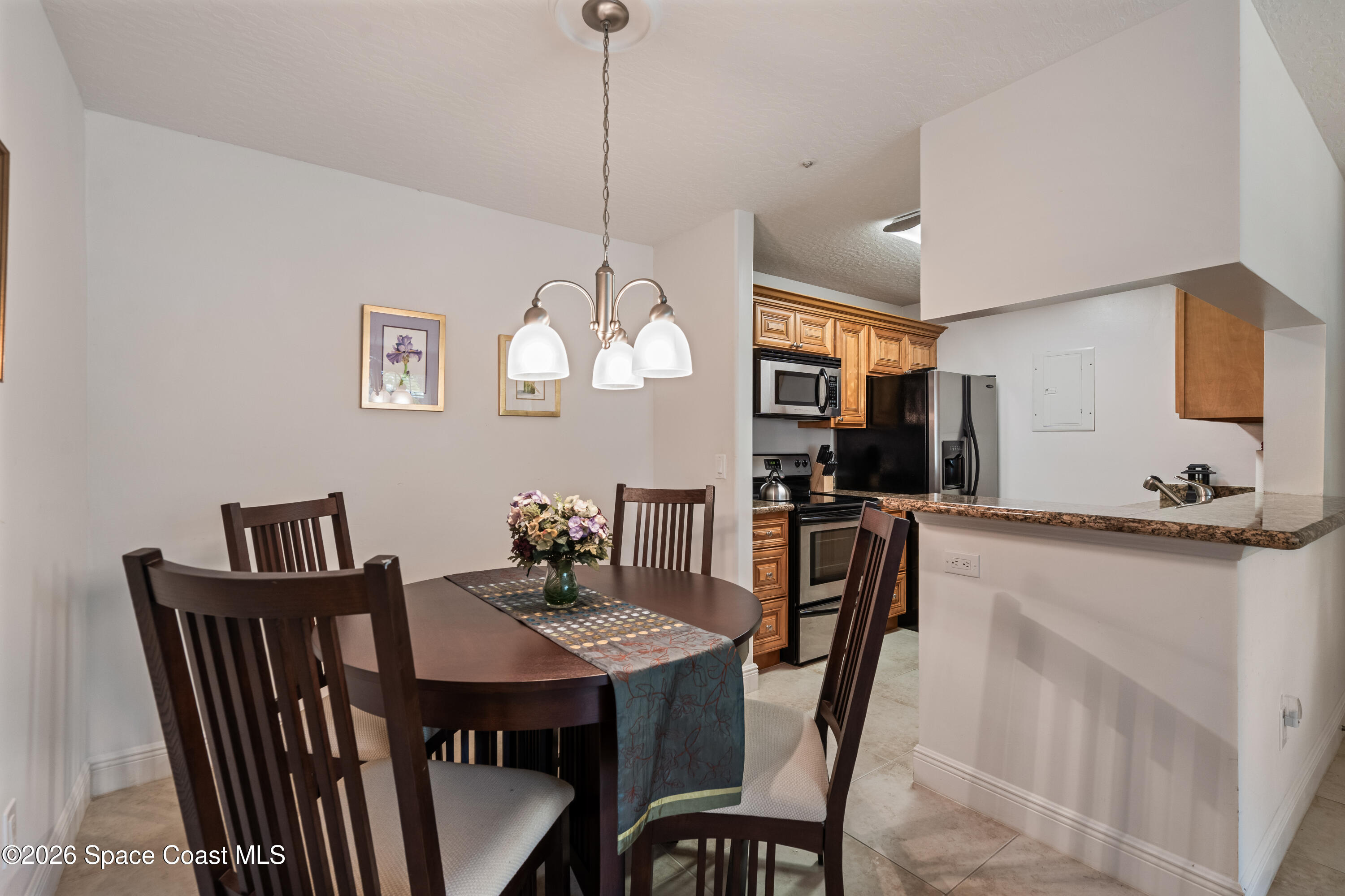 7667 North Wickham Road, Unit 208 Melbourne, FL 32940 - Photo 10 of 33 a view of a dining room and a kitchen island with furniture
