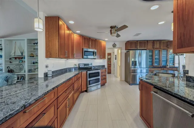 a kitchen with stainless steel appliances granite countertop wooden cabinets a stove top oven a sink and dishwasher