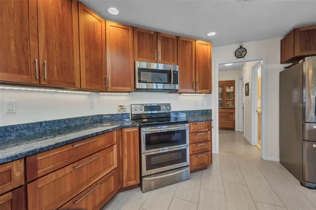 a kitchen with kitchen island granite countertop a sink and a large window