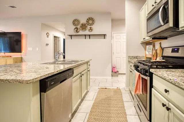 a kitchen with stainless steel appliances granite countertop a stove and a sink