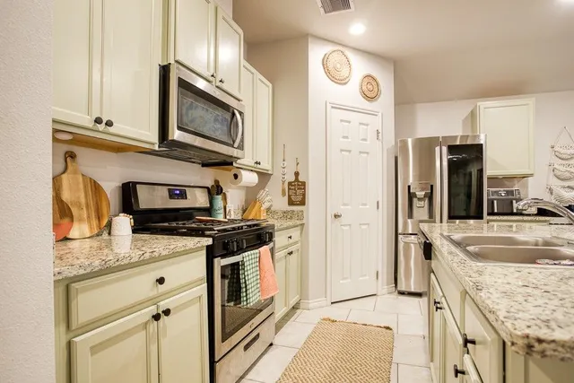 a kitchen with stainless steel appliances granite countertop a refrigerator stove and sink