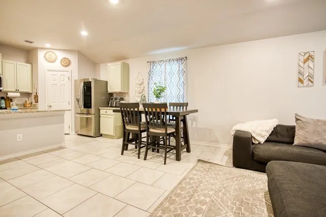 a living room with furniture and a dining table with kitchen view