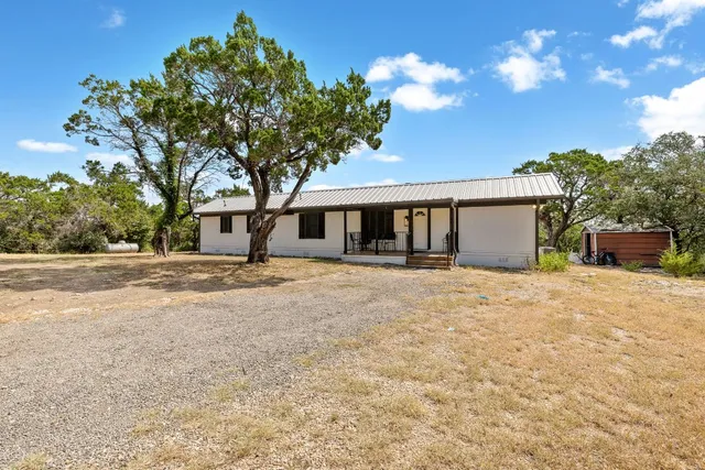 a front view of a house with a yard and potted plants