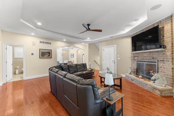a large kitchen with stainless steel appliances granite countertop a stove a sink dishwasher a oven and a dining table with wooden floor