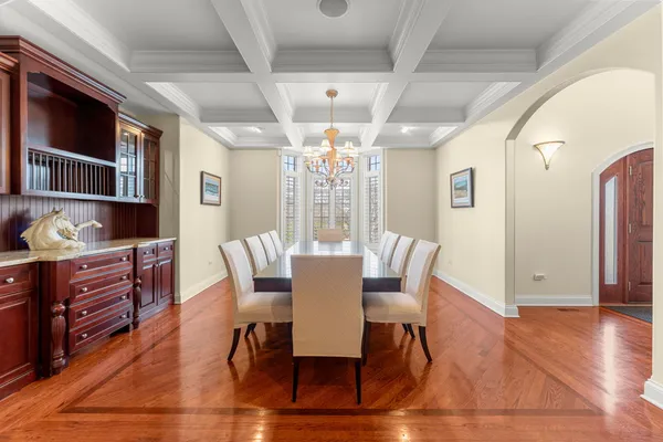 a living room with furniture floor to ceiling window hardwood floor and a flat screen tv