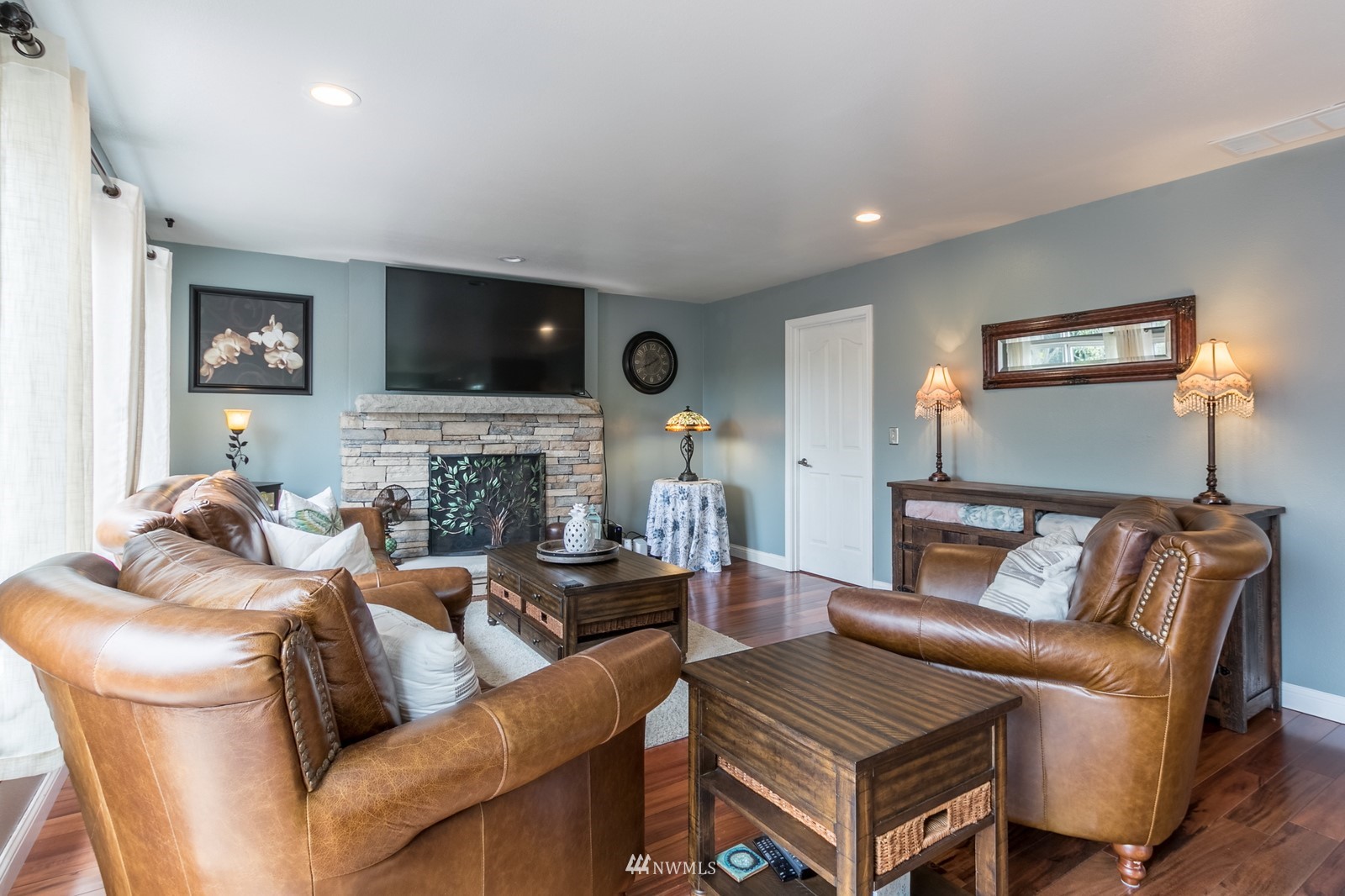 7413 Vandermark Road East Bonney Lake, WA 98391 - Photo 14 of 39 a living room with furniture a flat screen tv and a fireplace