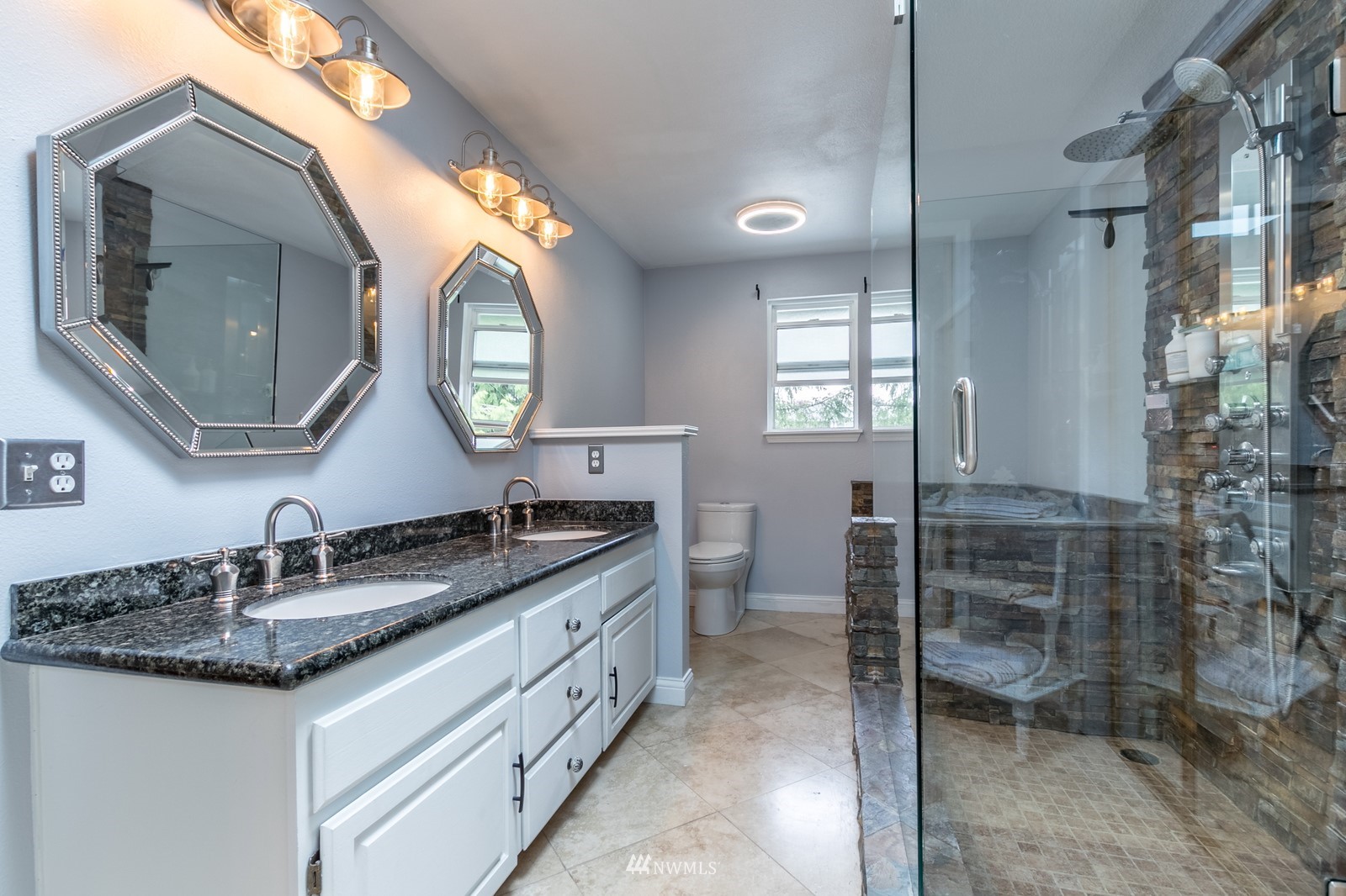 7413 Vandermark Road East Bonney Lake, WA 98391 - Photo 23 of 39 a bathroom with a granite countertop sink a toilet and a mirror