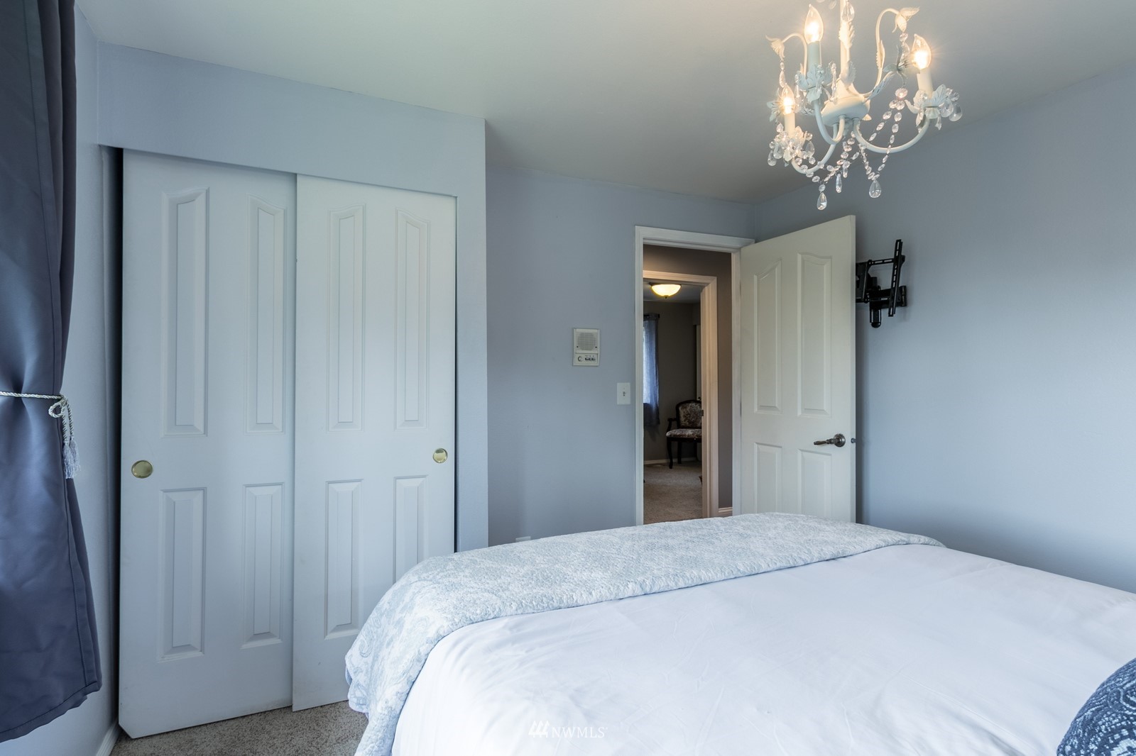 7413 Vandermark Road East Bonney Lake, WA 98391 - Photo 24 of 39 a bedroom with a bed and a chandelier