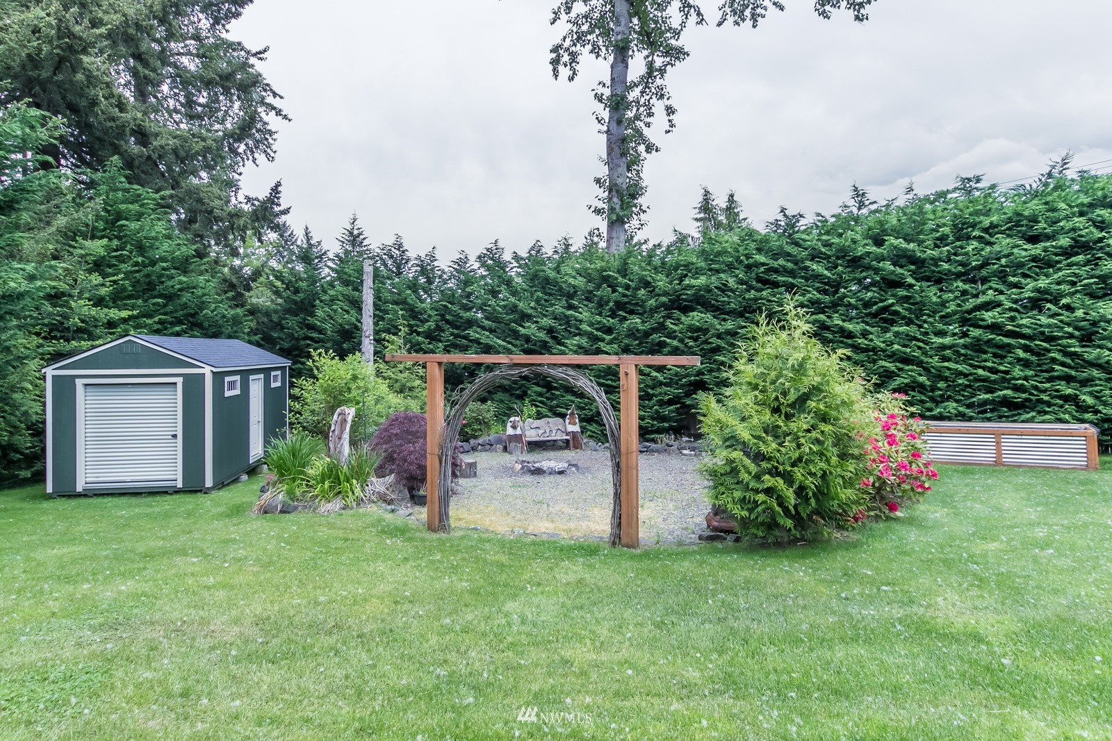 7413 Vandermark Road East Bonney Lake, WA 98391 - Photo 36 of 39 a view of a backyard with potted plants and large trees