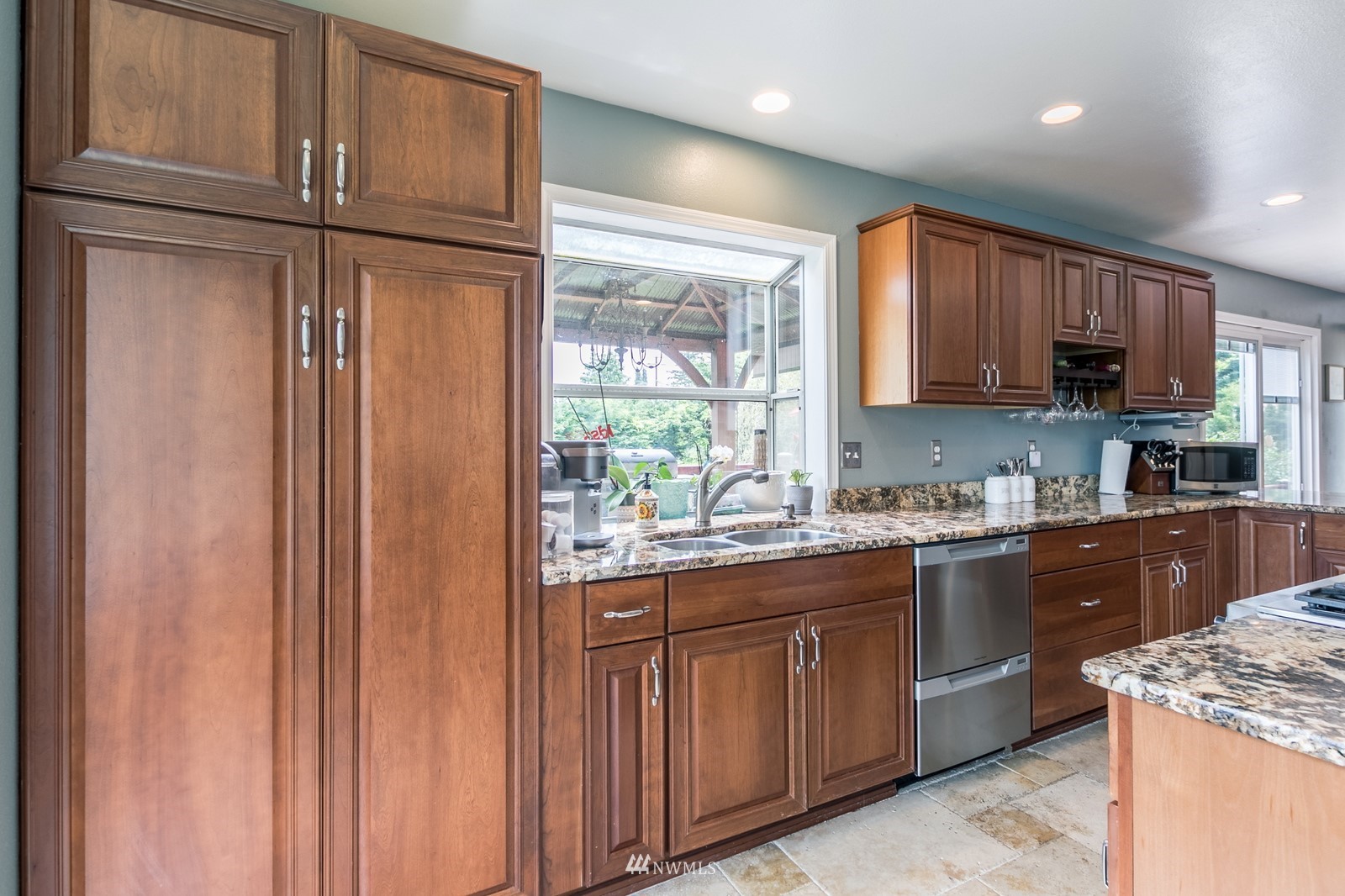 7413 Vandermark Road East Bonney Lake, WA 98391 - Photo 7 of 39 a kitchen with kitchen island granite countertop wooden cabinets stainless steel appliances a sink and a window