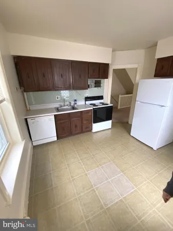a kitchen with stainless steel appliances a sink a stove top oven a counter space and cabinets