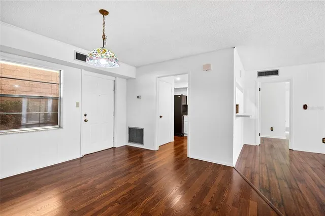 a view of empty room with wooden floor