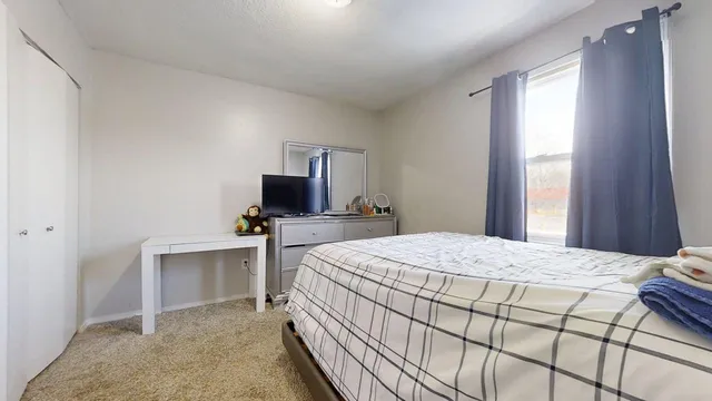 a bedroom with a bed and a flat tv screen in a room