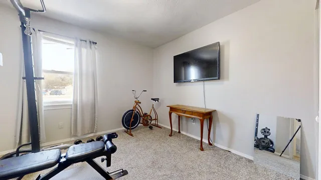 a view of a workspace with furniture and a window