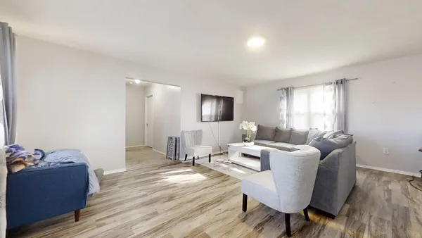 a living room with furniture and a wooden floor