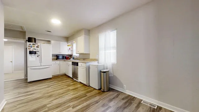 a kitchen with white cabinets and white appliances