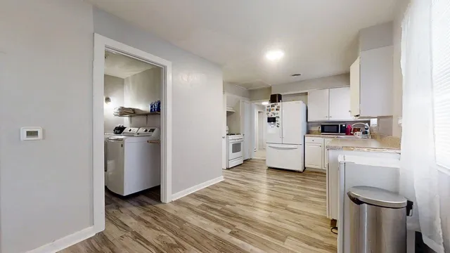 a kitchen with white cabinets and white appliances