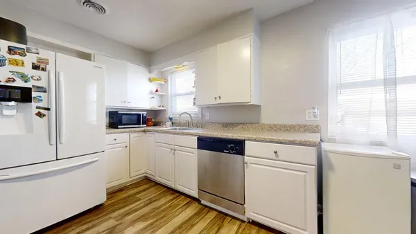 a kitchen with granite countertop white cabinets and white appliances