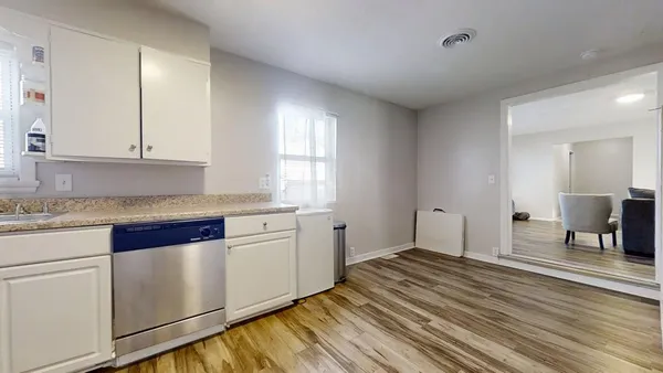 a kitchen with granite countertop white cabinets and white appliances