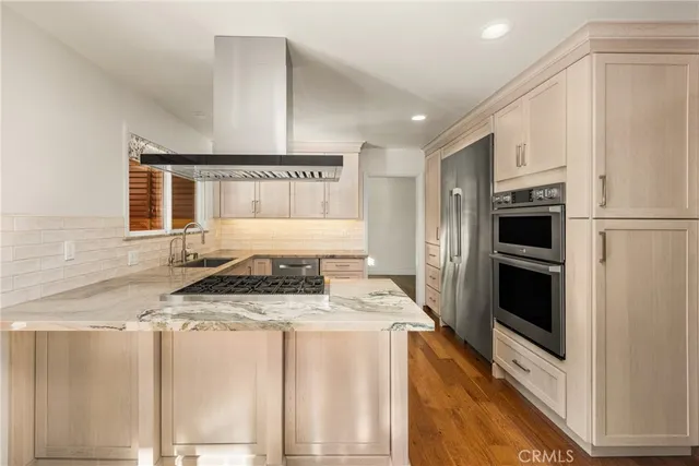 a kitchen with stainless steel appliances granite countertop a stove a refrigerator and a microwave