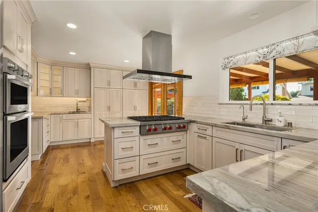 a kitchen with stainless steel appliances kitchen island granite countertop a stove a sink and a microwave
