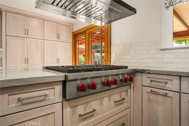 a kitchen with stainless steel appliances cabinets and a large window