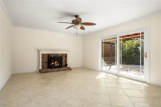a view of an empty room with windows and a fireplace