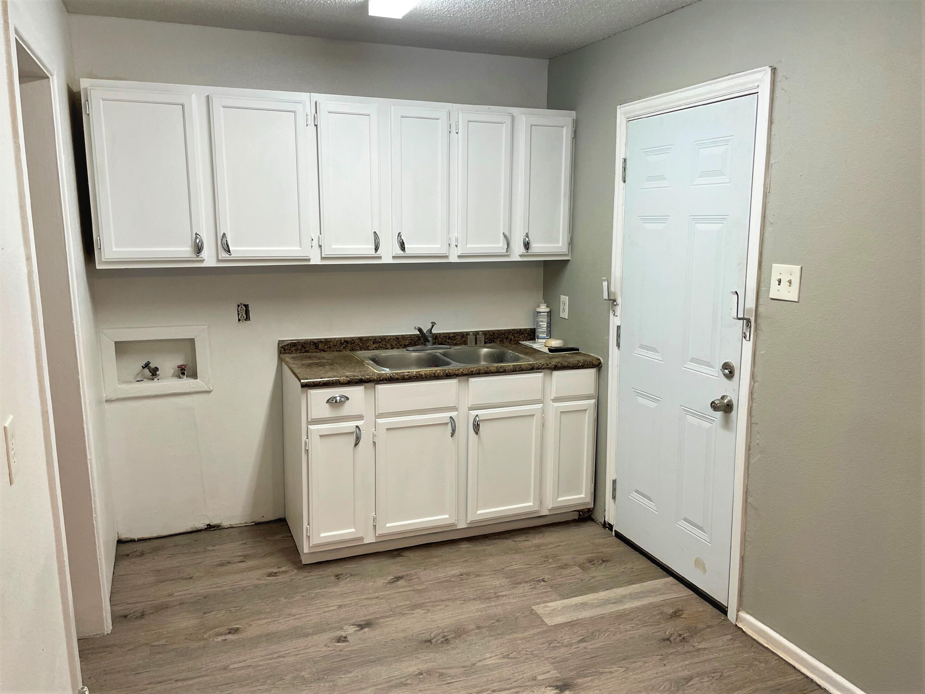 2718 East 10th Street Lubbock, TX 79403 - Photo 2 of 9 a kitchen with white cabinets and white appliances