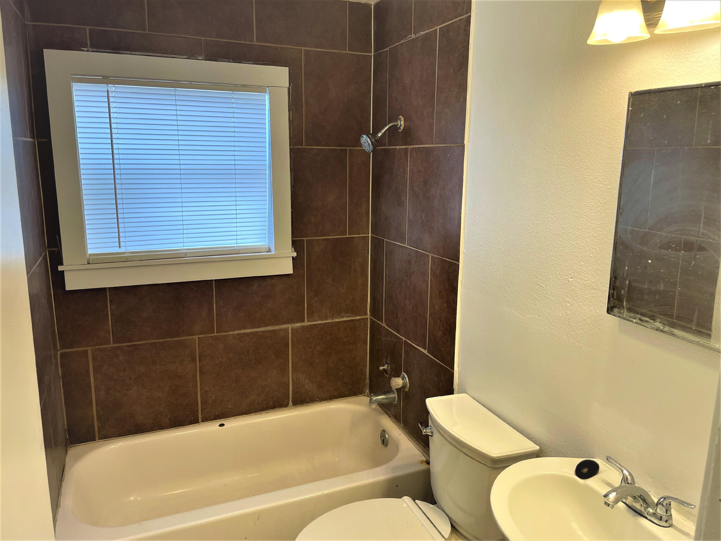 2718 East 10th Street Lubbock, TX 79403 - Photo 6 of 9 a bathroom with a toilet and shower