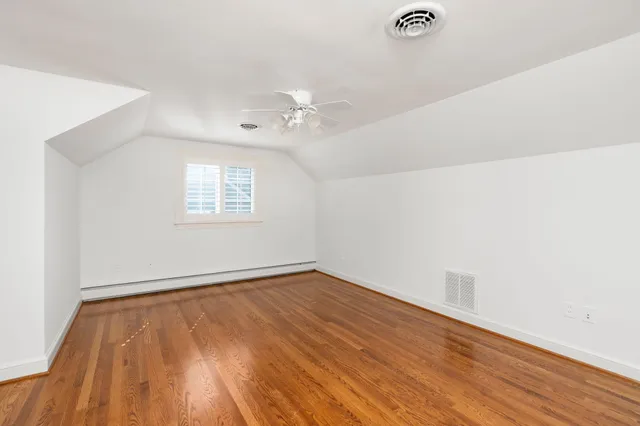 a view of a house with brick walls and a yard with plants
