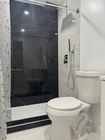a bathroom with a toilet and a shower
