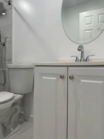 a bathroom with a toilet a sink and mirror