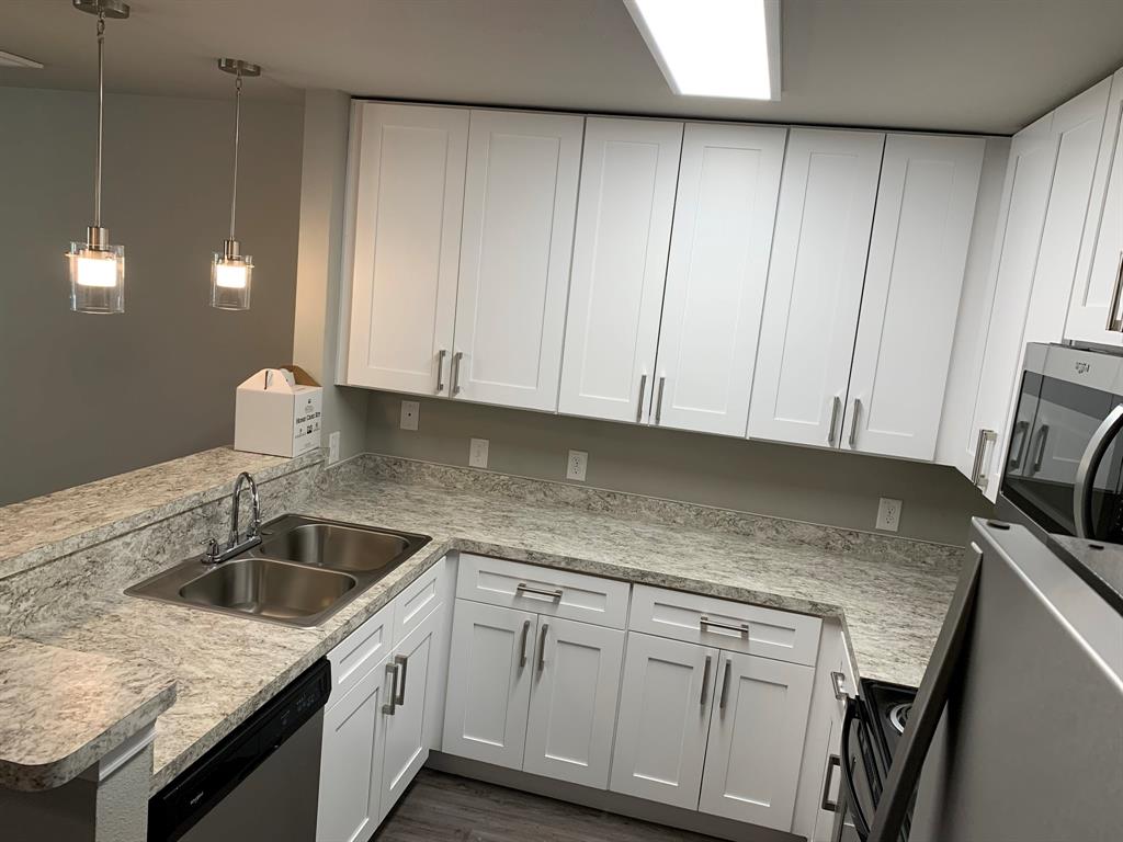 6108 Abrams Road, Unit 514 Dallas, TX 75231 - Photo 2 of 9 a kitchen with granite countertop cabinets sink and washing machine