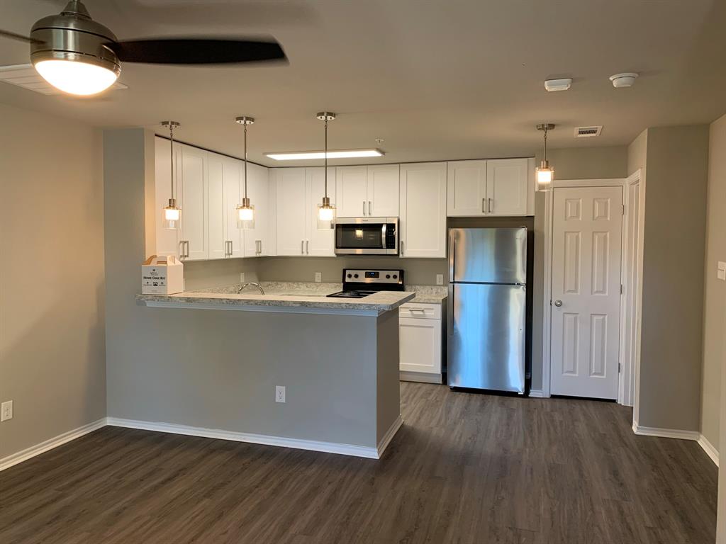 6108 Abrams Road, Unit 514 Dallas, TX 75231 - Photo 3 of 9 a kitchen with granite countertop a refrigerator and a stove top oven