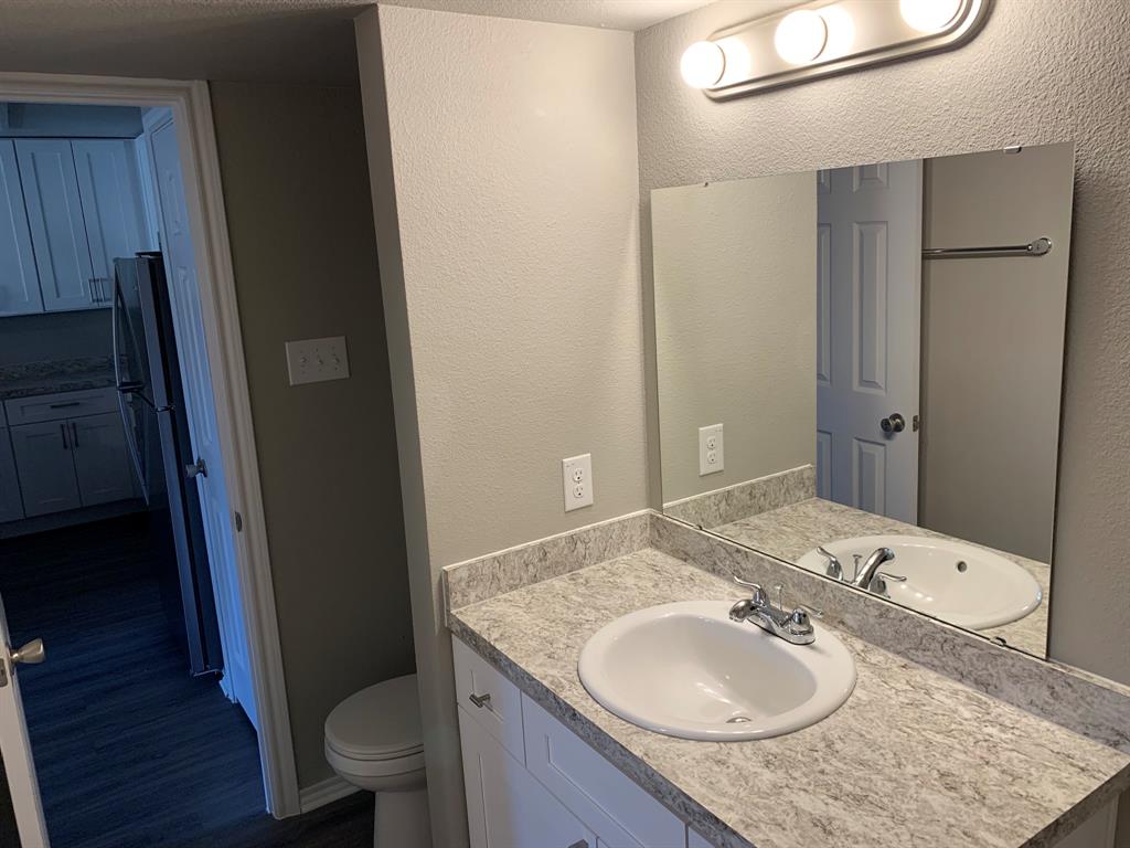 6108 Abrams Road, Unit 514 Dallas, TX 75231 - Photo 8 of 9 a bathroom with a granite countertop sink toilet and shower