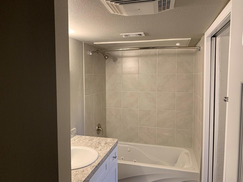 6108 Abrams Road, Unit 514 Dallas, TX 75231 - Photo 9 of 9 a bathroom with a granite countertop bathtub shower sink and vanity