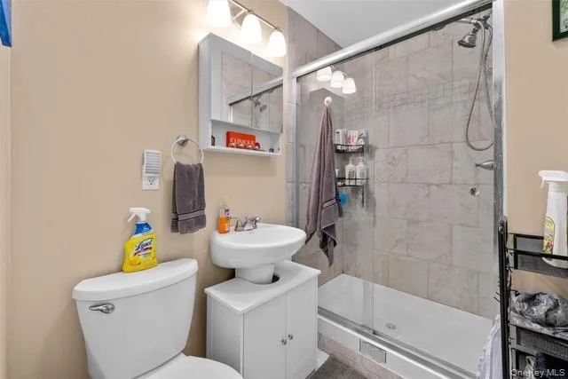 a bathroom with a sink a toilet and shower