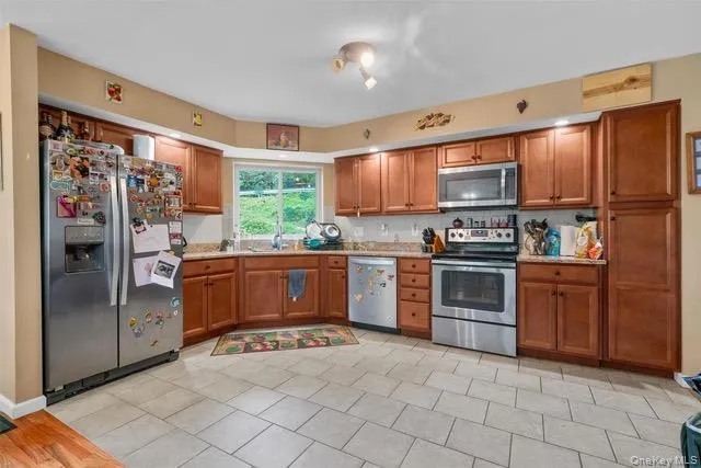 a kitchen with stainless steel appliances granite countertop a refrigerator and a stove top oven