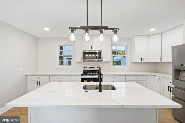 a kitchen with stainless steel appliances a sink stove and refrigerator