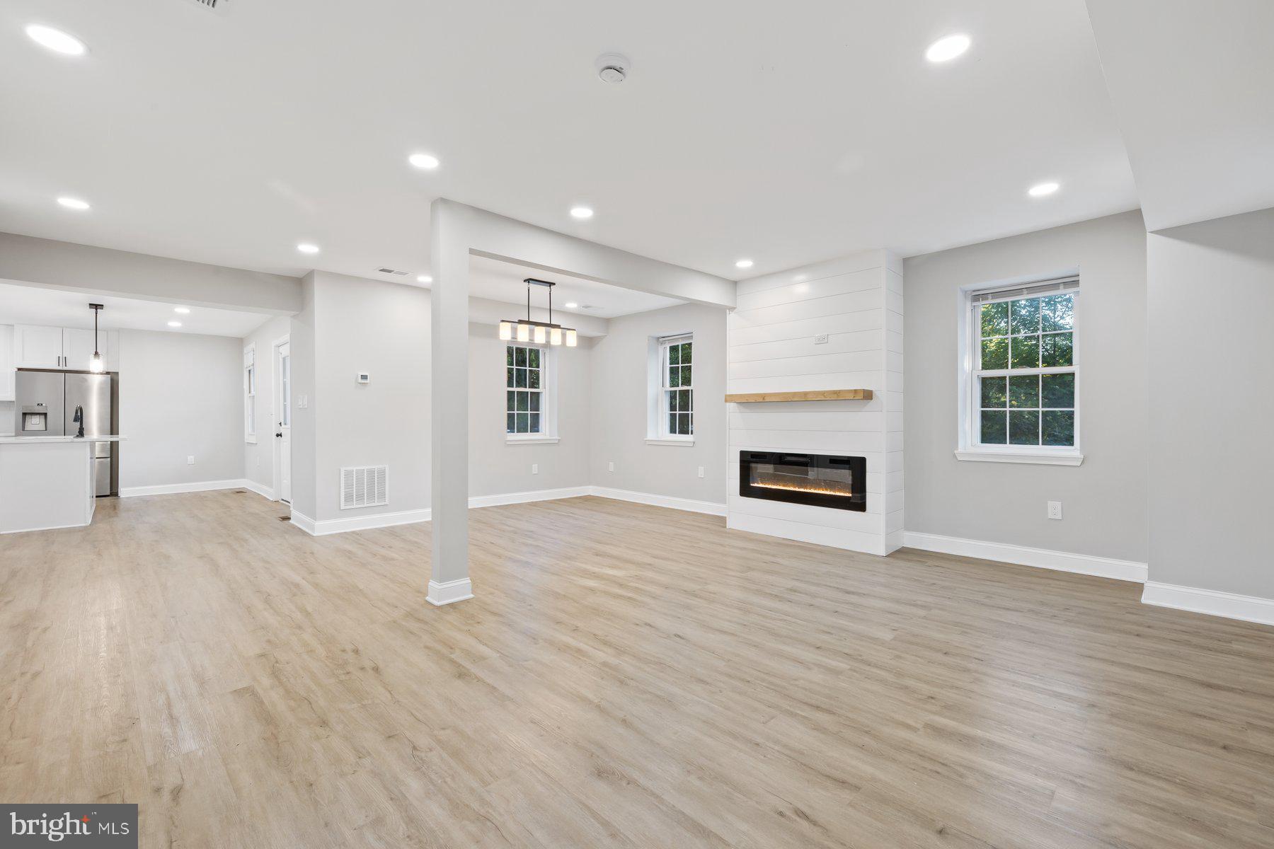 8109 Old Hagerstown Road Middletown, MD 21769 - Photo 2 of 54 an empty room with wooden floor fireplace and windows