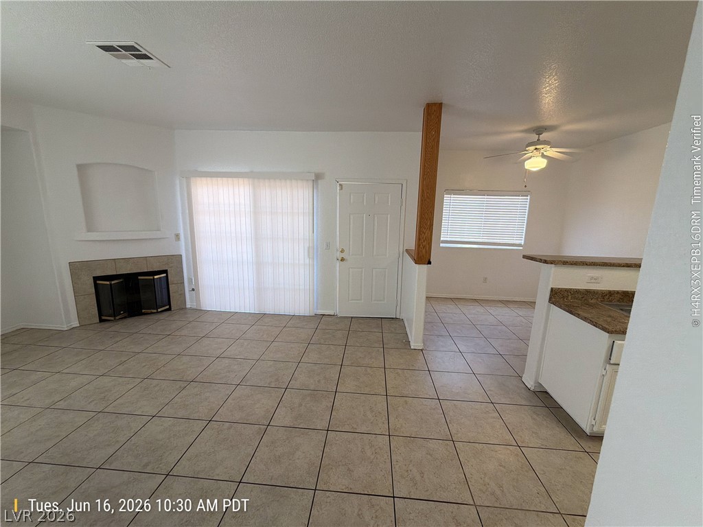 4730 East Craig Road, Unit 1124 Las Vegas, NV 89115 - Photo 5 of 22 A functional living space features a tiled fireplace, offering warmth and ambiance.