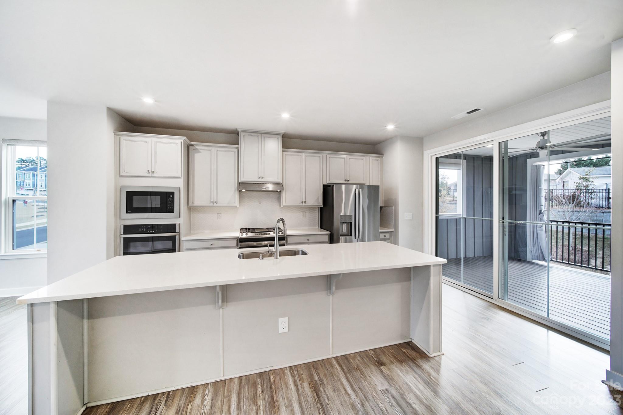 622 Crudent Road Tega Cay, SC 29708 - Photo 14 of 40 a large kitchen with stainless steel appliances a large counter top a stove and a refrigerator