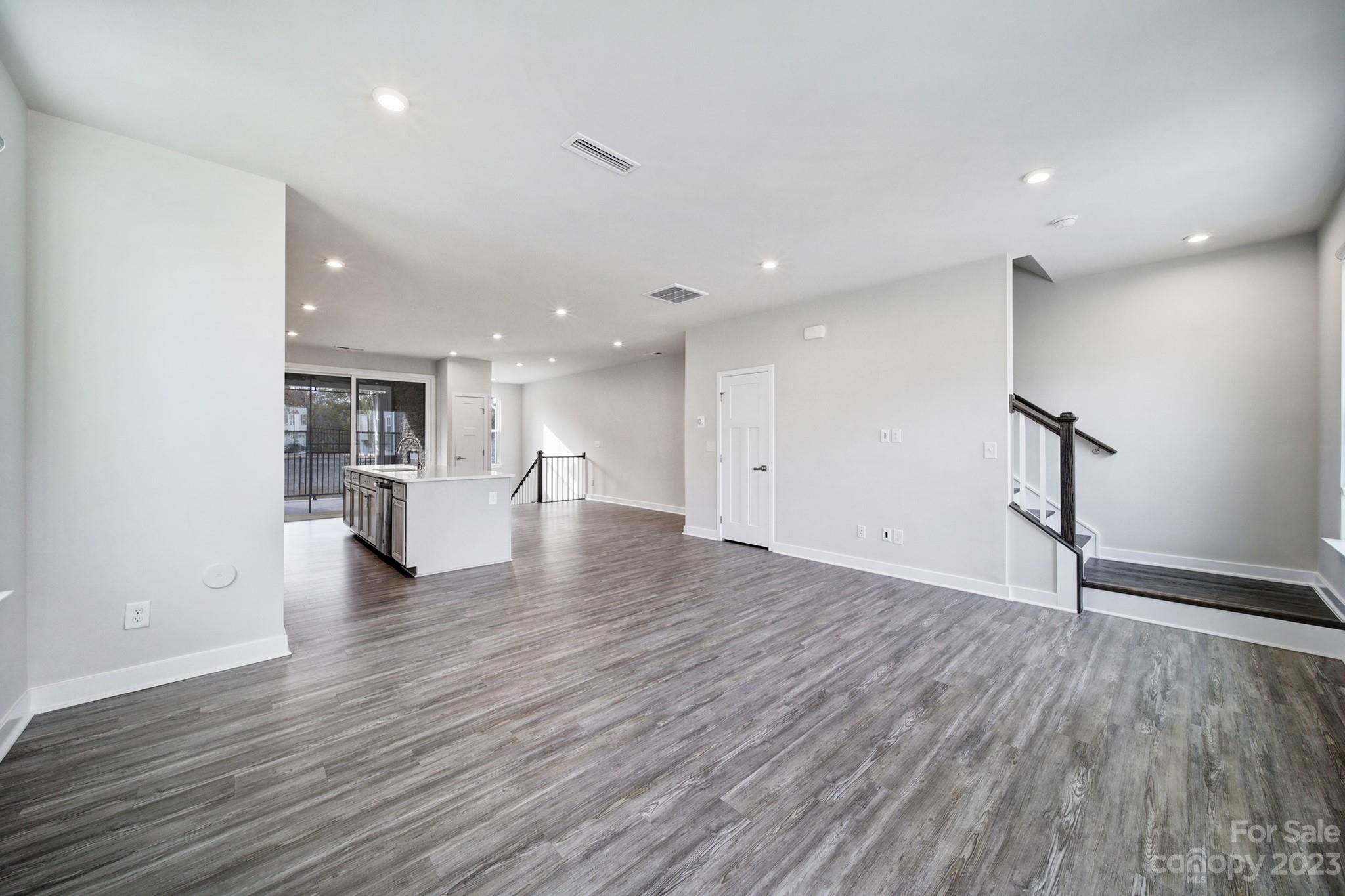 622 Crudent Road Tega Cay, SC 29708 - Photo 20 of 40 a view of an empty room with wooden floor and a kitchen