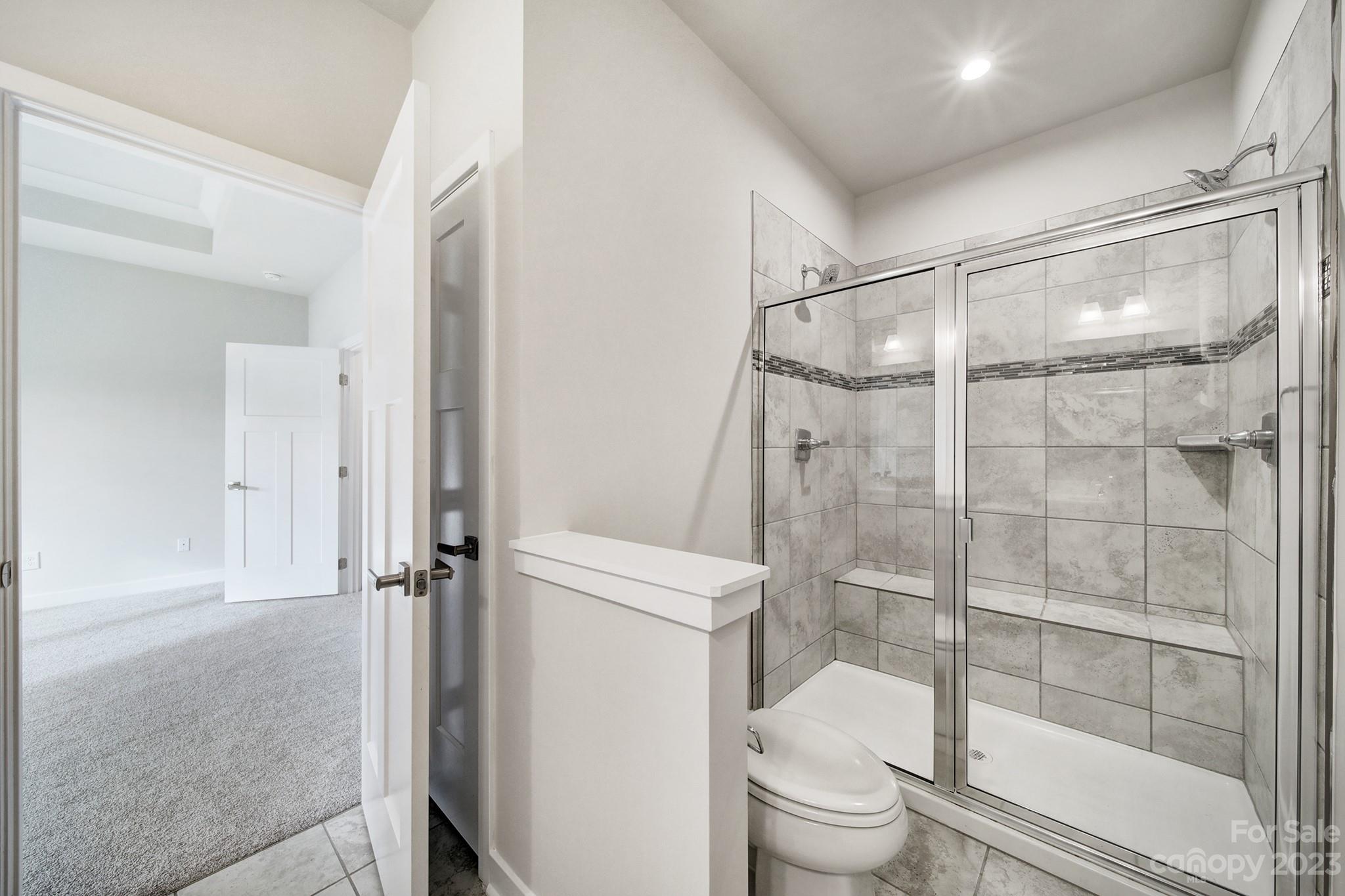 622 Crudent Road Tega Cay, SC 29708 - Photo 33 of 40 a bathroom with a granite countertop toilet and a shower