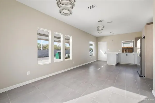 a view of a big room with windows and chandelier fan