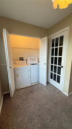 a view of a lake with a yard and large trees