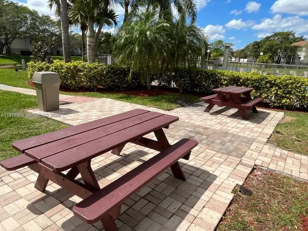 a view of outdoor space with green field and trees in the background
