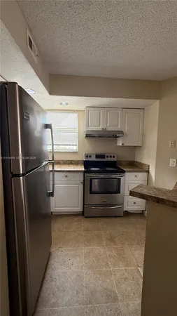 a kitchen with stainless steel appliances a refrigerator and a stove