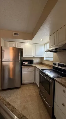a kitchen with a refrigerator stove and cabinets