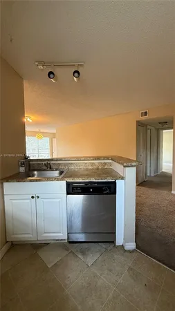 a view of a kitchen with a sink and a fireplace